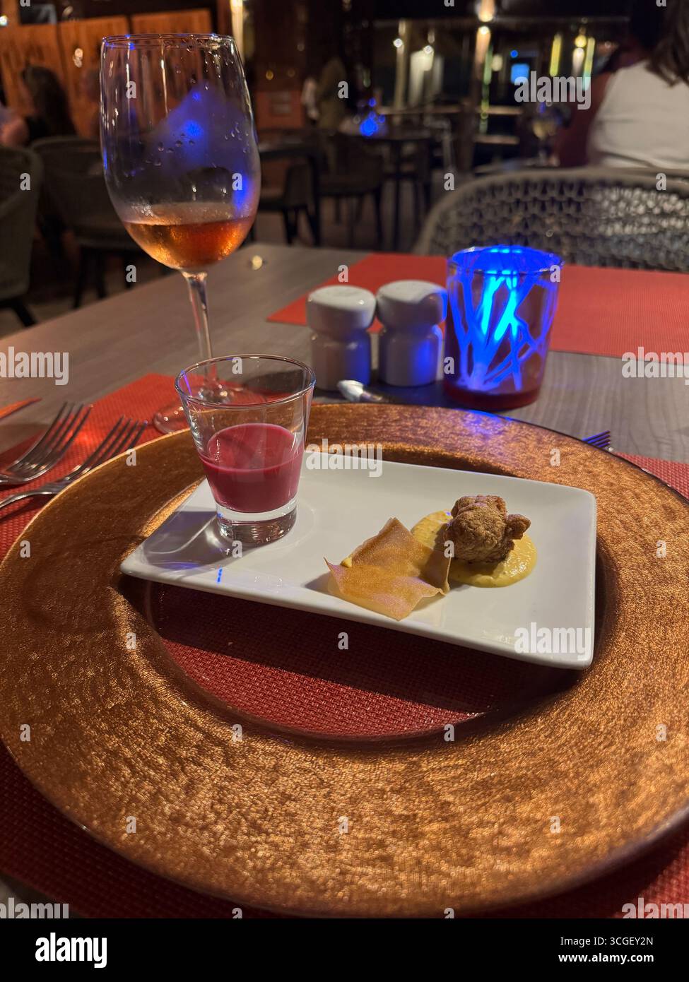 Elegant fine dining starter plate with wine glass in a tropical restaurant, Zanzibar, Tanzania, showcasing gourmet holiday cuisine and resort lifestyle - Smartphone Captured Stock Image