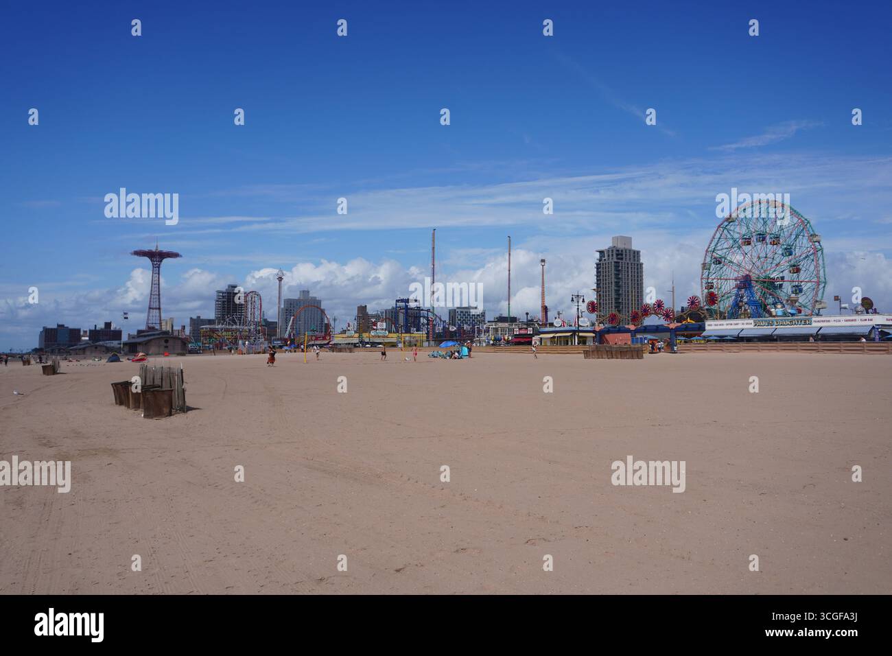 Skyline of Coney Island’s amusement park in Brooklyn, New York City, featuring rides, rollercoasters, and the Wonder Wheel against a bright summer sky Stock Photo
