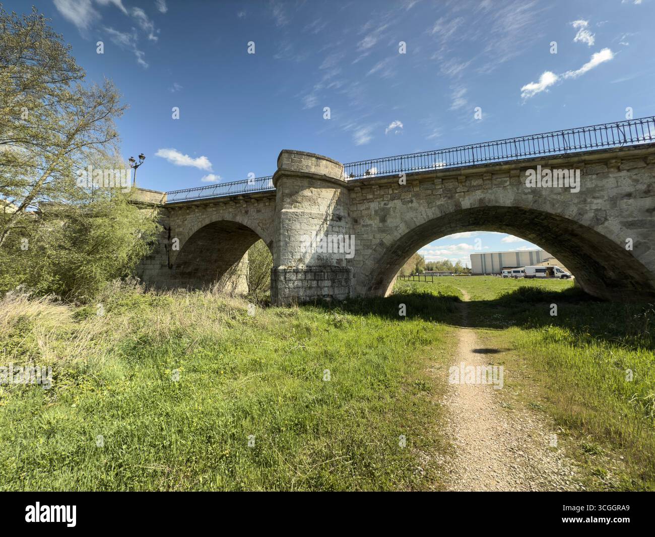 Stone bridge with multiple arches and lampposts crossing a river in a ...