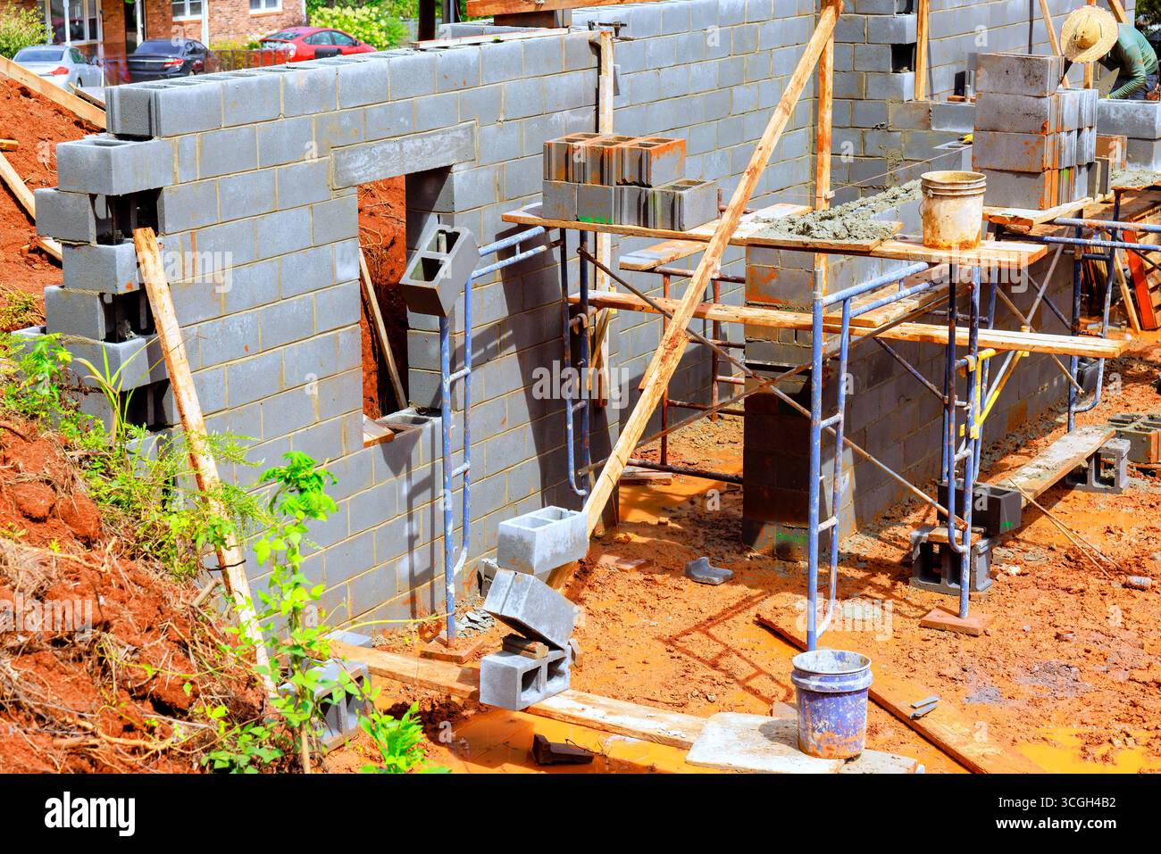 Construction workers are actively assembling concrete block wall on ...