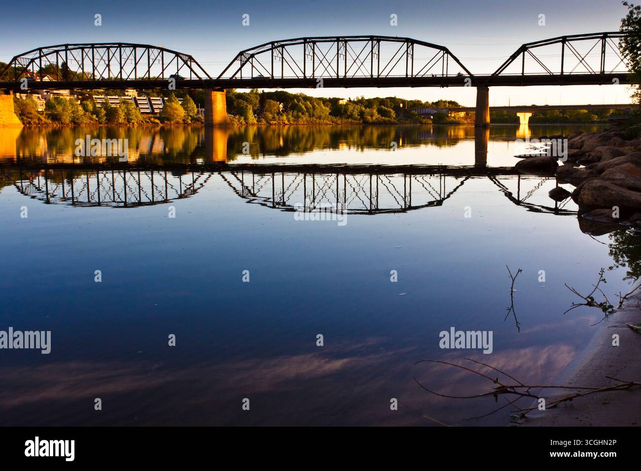 A modern steel structure, the rebuilt Traffic Bridge spans the South Saskatchewan River, reconnecting downtown Saskatoon with the east side. Stock Photo