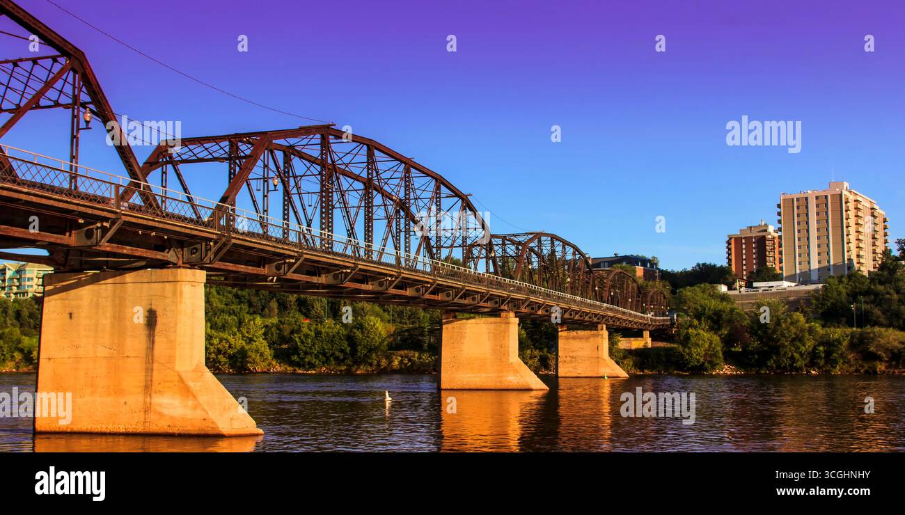 A modern steel structure, the rebuilt Traffic Bridge spans the South Saskatchewan River, reconnecting downtown Saskatoon with the east side. Stock Photo