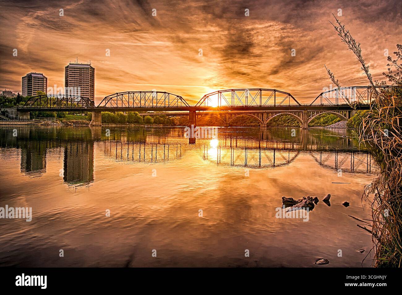 A modern steel structure, the rebuilt Traffic Bridge spans the South Saskatchewan River, reconnecting downtown Saskatoon with the east side. Stock Photo