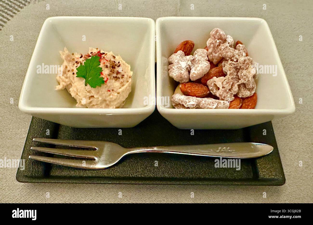 Gourmet tuna amuse-bouche with caramelized almonds and walnuts pairing Stock Photo