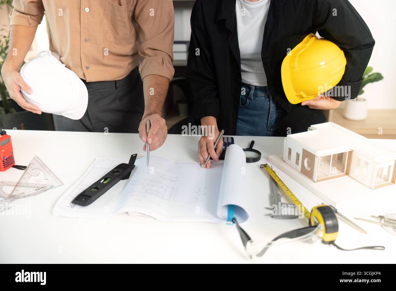 Architects Collaborating on Building Plans and Models Stock Photo