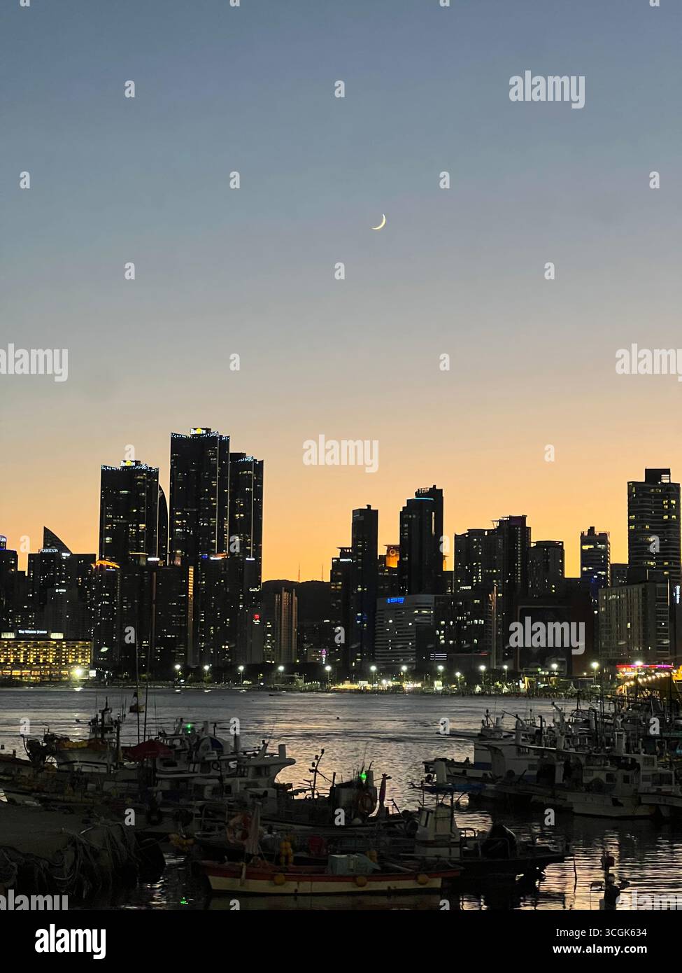 Night view of Haeundae skyline in Busan, South Korea, with city lights shining over the sea as seen from Mipo breakwater. - Smartphone Captured Stock Image