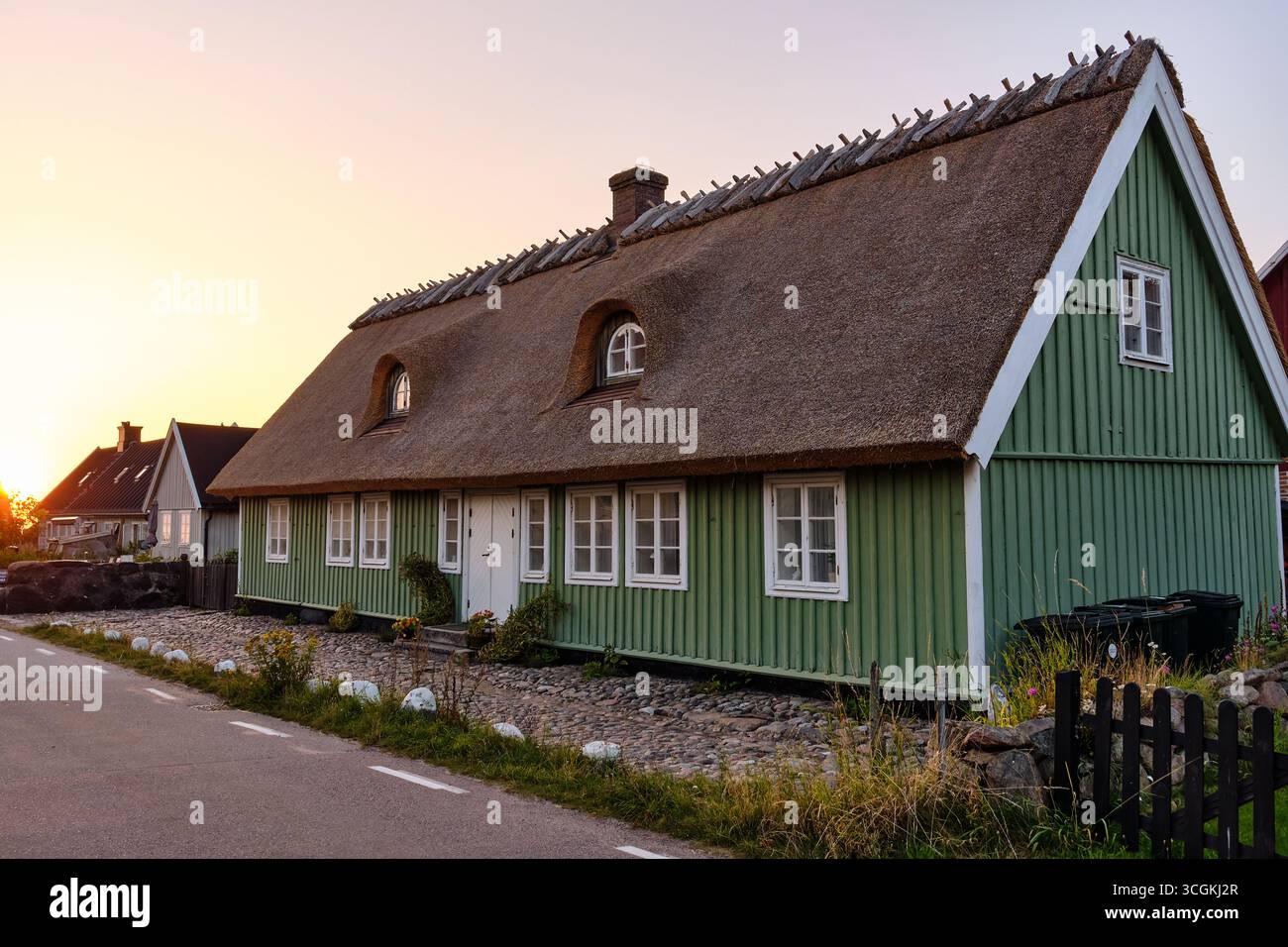 Lerhamn, Sweden ; August 13, 2025: Romantic Swedish coastal houses with thatched roofs in soft evening light, Skåne län. Stock Photo