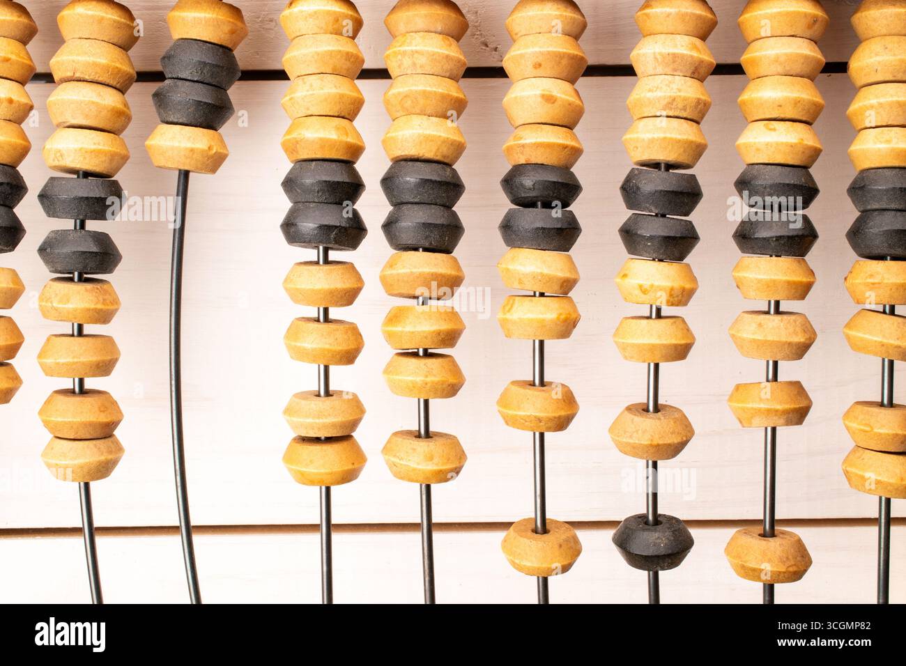 A calculator, which is a mechanical computing device for performing arithmetic operations, on a wooden table, close-up, top view. Stock Photo