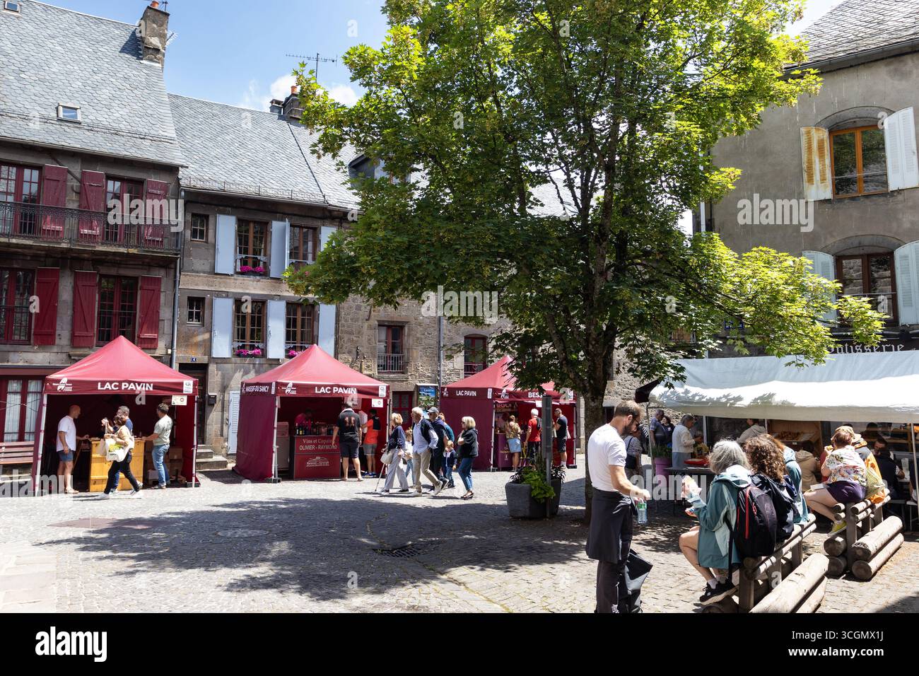 BESSE, FRANCE, 20 JULY 2025: The old town center streets of Besse-et-Saint-Anastaise during a local produce market. The annual summer market is enjoye - Stock Image