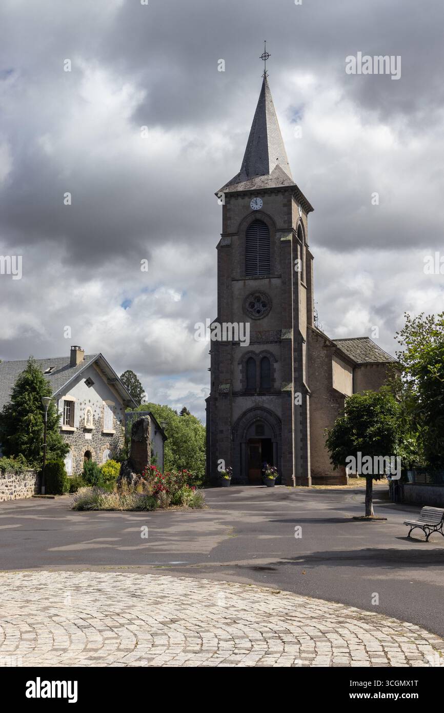 The church of Saint Ferreol, and the lovely town square in Murol, a town in Puy-de-Dome, in the Auvergne, France. - Stock Image