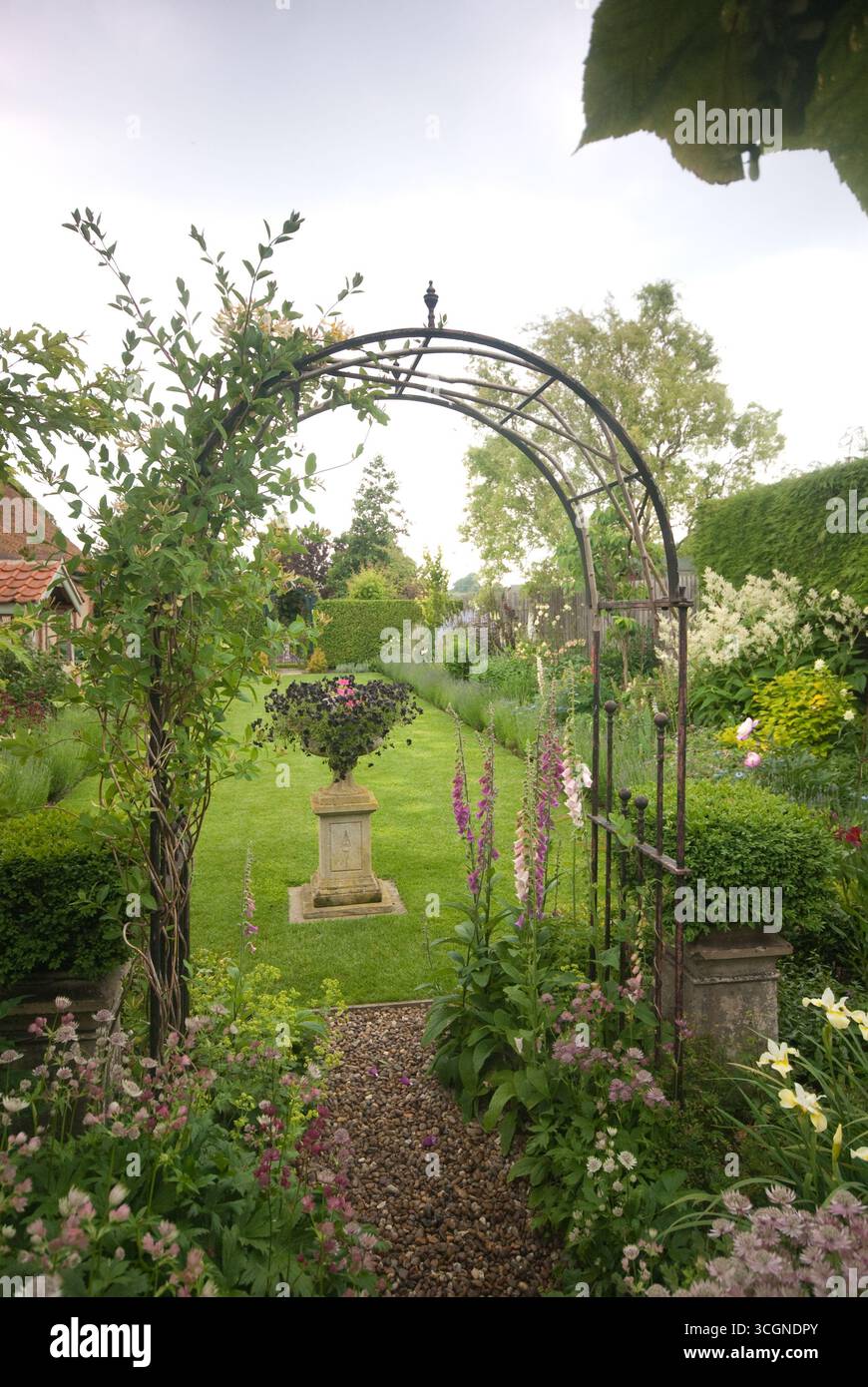 A scenic garden showcases an elegant archway adorned with climbing ...