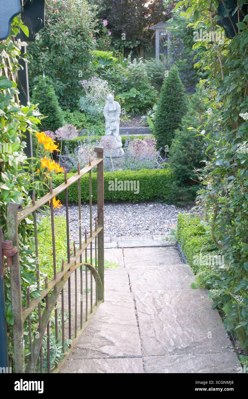 A rustic pathway guides visitors into a vibrant garden adorned with ...