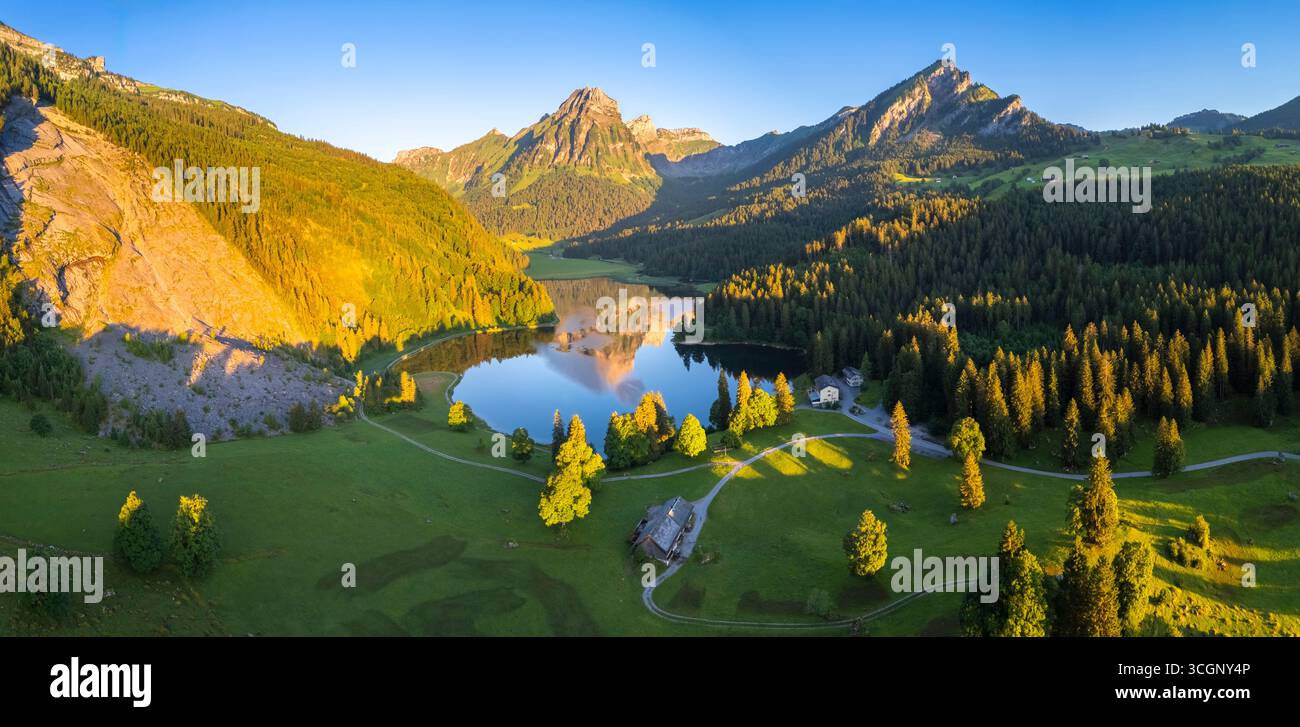 Aerial view of Barensoolspitz and Brunnelistock peaks at sunrise reflected in the Obersee lake. Näfels, Oberseealp, Canton of  Glarus, Switzerland. Stock Photo