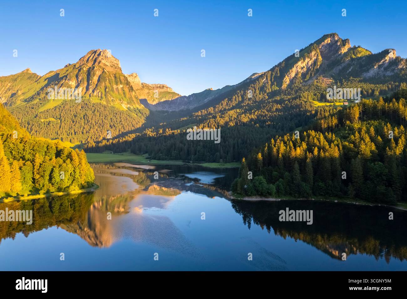 Aerial view of Barensoolspitz and Brunnelistock peaks at sunrise reflected in the Obersee lake. Näfels, Oberseealp, Canton of  Glarus, Switzerland. Stock Photo