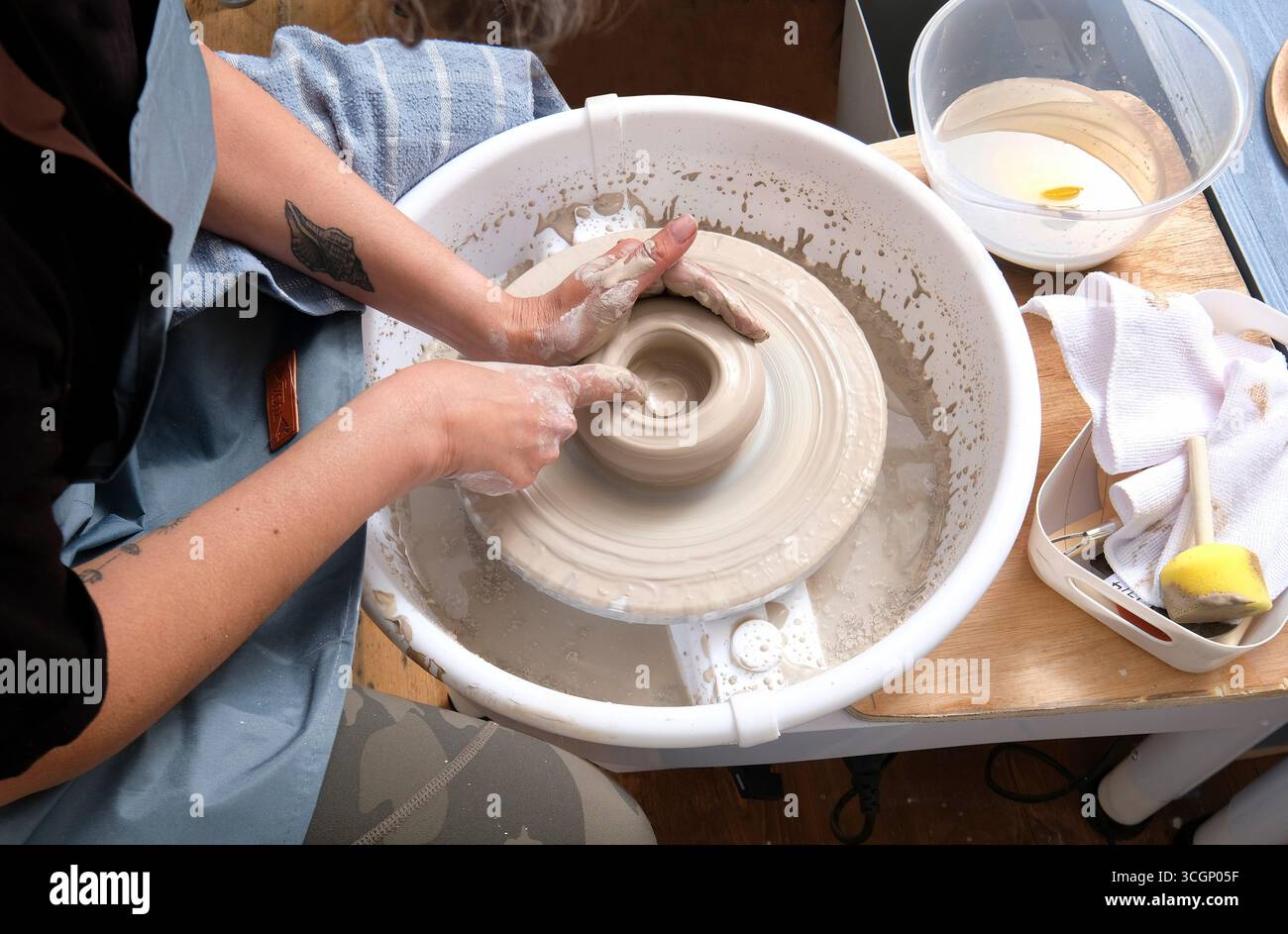 potter making clay bowl on potters wheel, norfolk, england Stock Photo