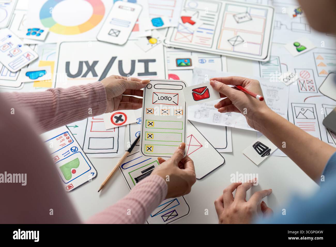 UX and UI Design Exploration. Team discussing mobile app layout and design elements. Stock Photo