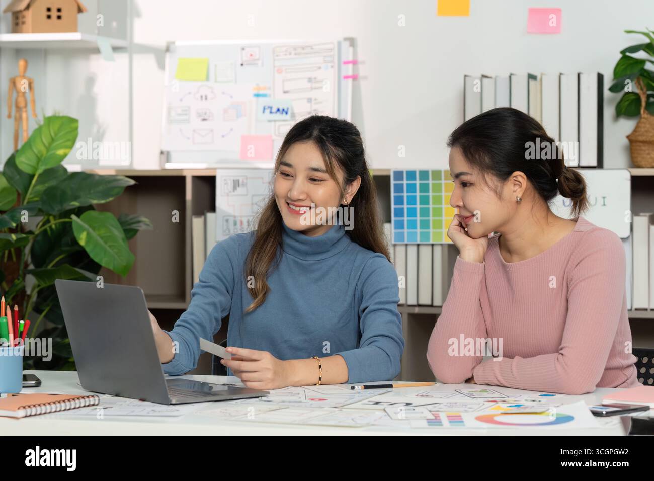 UX and UI designers discussing project ideas with laptop Stock Photo