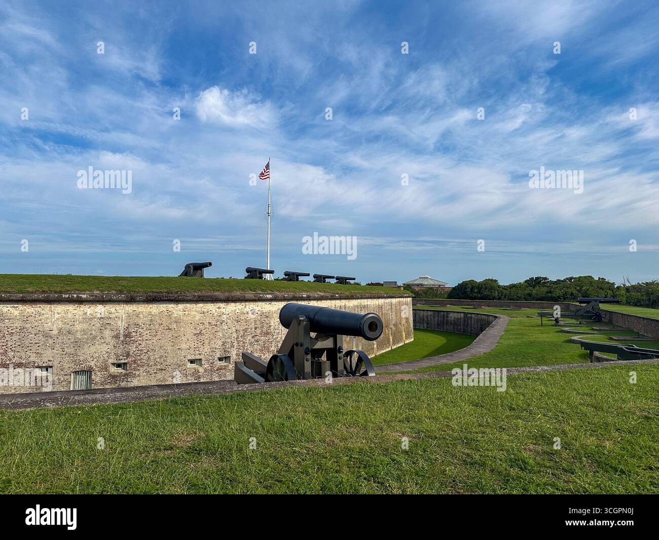 Row of historic cannons positioned along the grassy ramparts of Fort ...