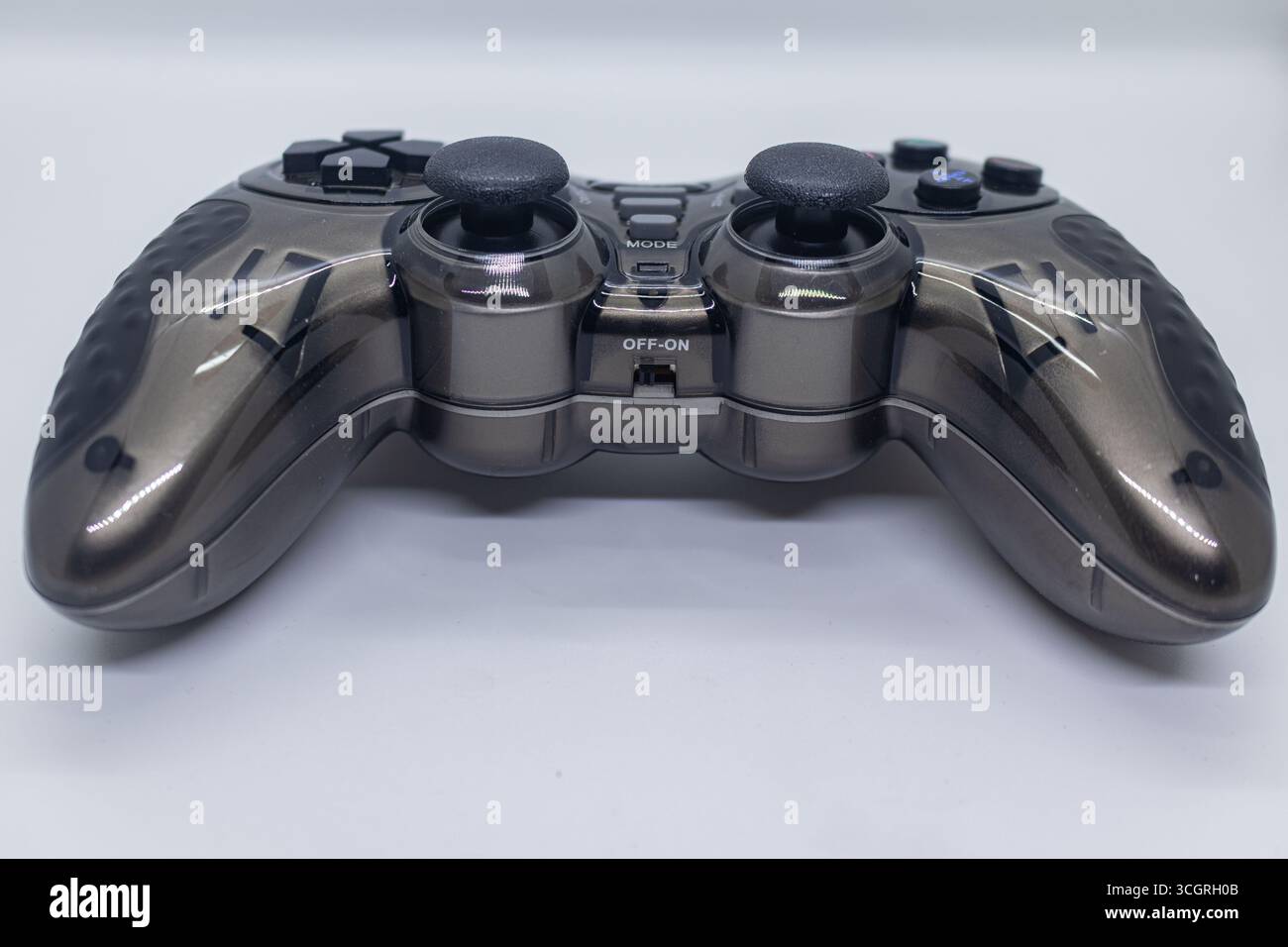 Ergonomic Black Gamepad with Textured Grip and Dual Analog Sticks on White Tabletop Background Stock Photo