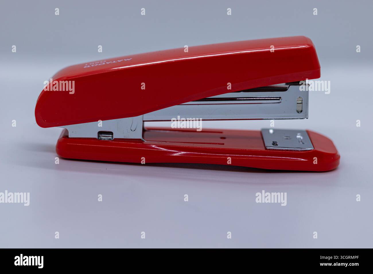 Plastic stapler with steel handle white backdrop Stock Photo