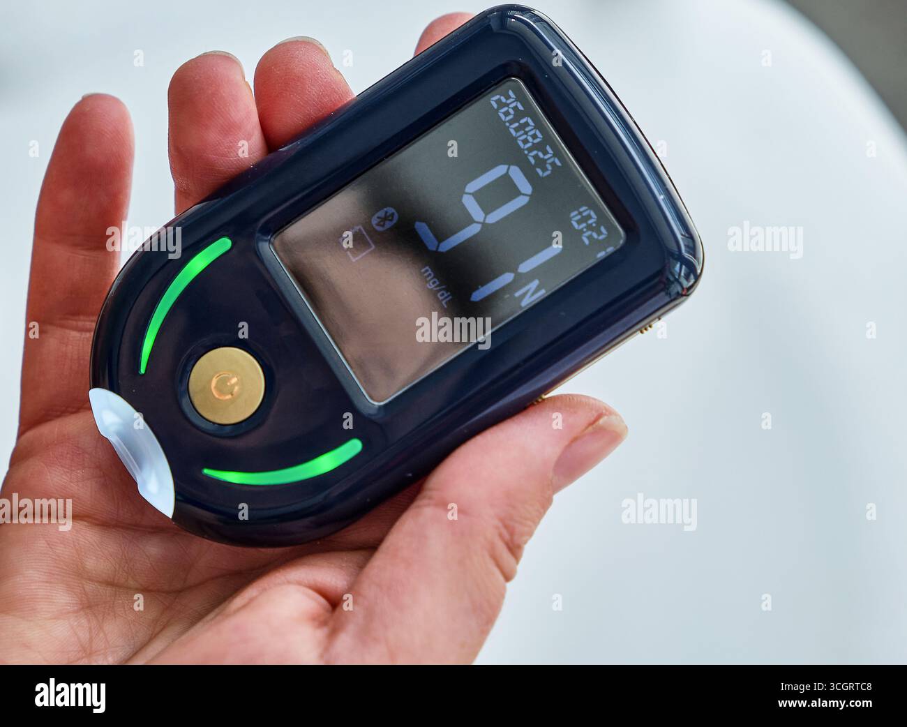 Close-up of a digital glucometer held in hand, displaying a 91 mg blood sugar reading. Device used for diabetes management and health monitoring. Stock Photo