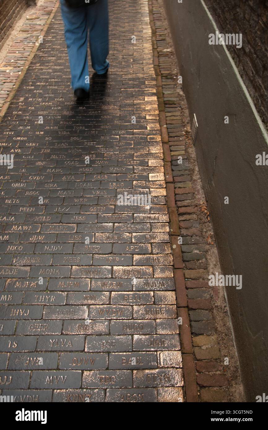 A walker along a path with slab paving with writing on it Stock Photo ...