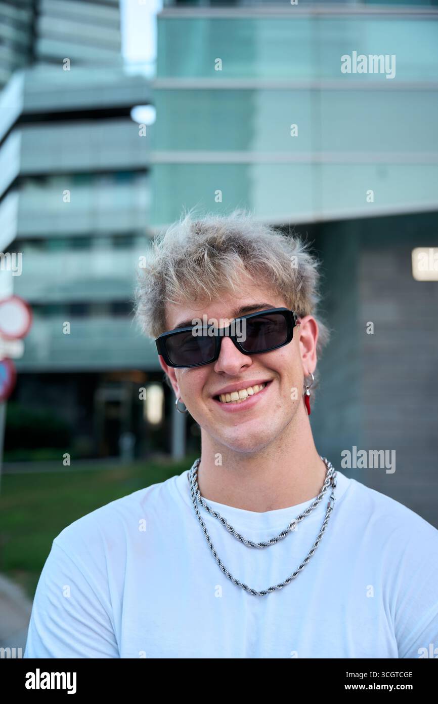 Blond gen z influencer smiling wearing sunglasses and silver chains Stock Photo
