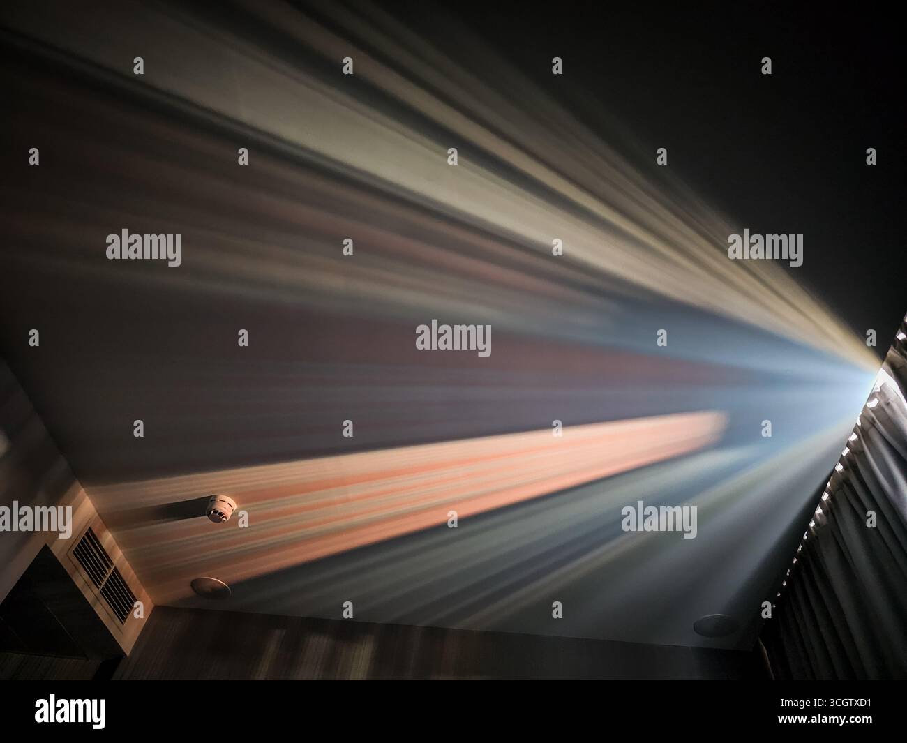 Multicolored Sunlight Beams Reflected Through Curtains Onto Ceiling Stock Photo