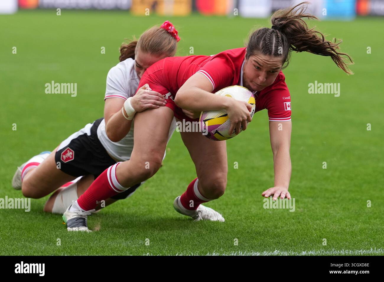 Taylor Perry of Canada, right, goes over the line to score a try ...