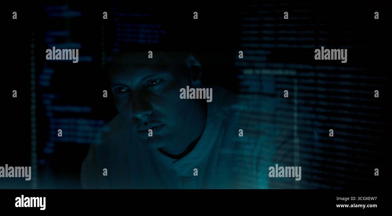 Programmers and coding. Programmer or Developer working in dark room with computer code reflected on their monitor. Cybersecurity software development Stock Photo