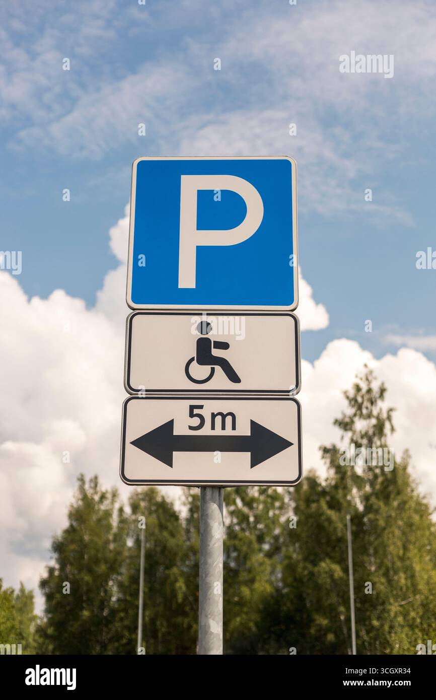 A sign displays parking regulations for accessible spaces with a ...