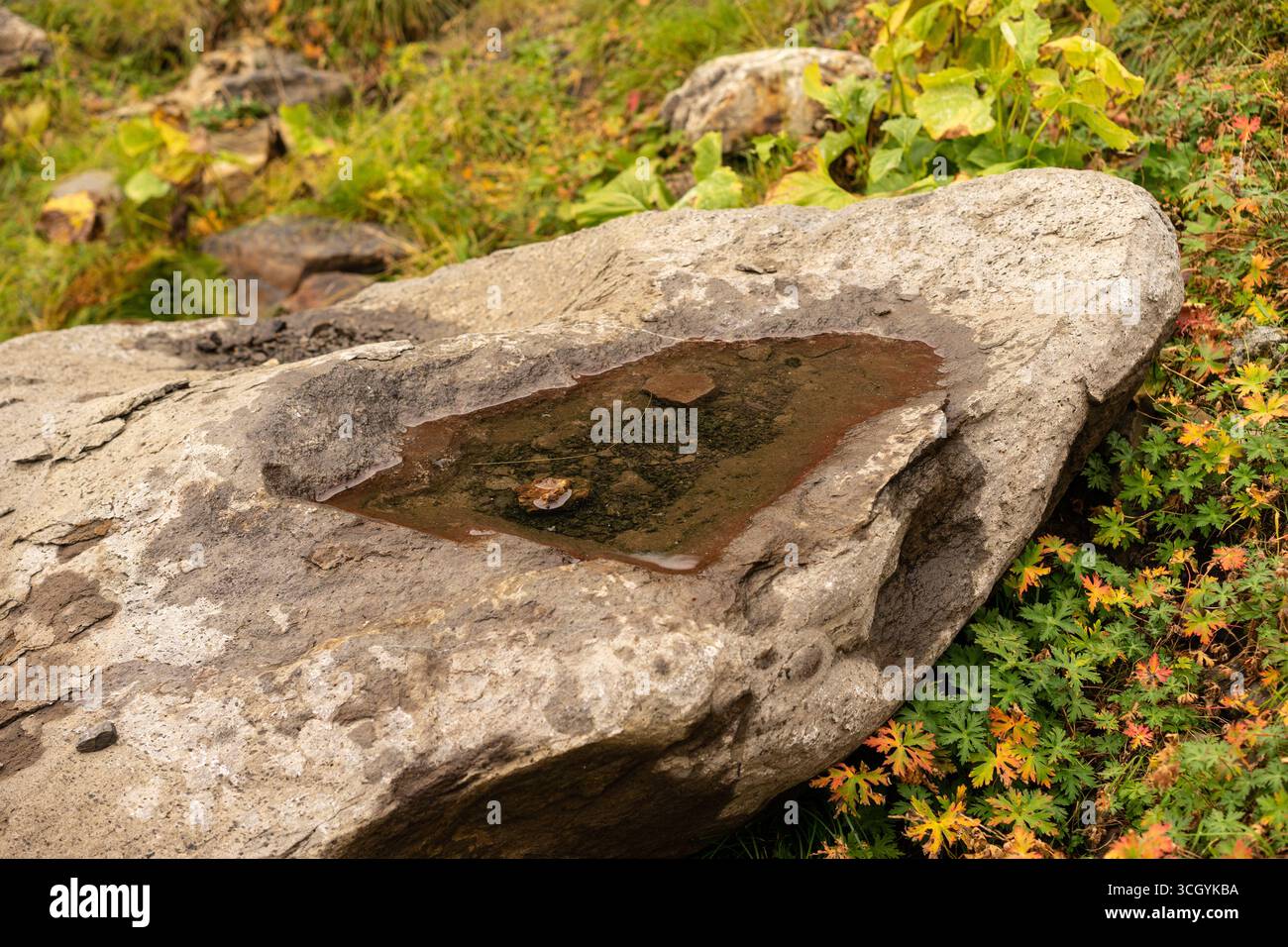 Rugged red rock formation with distinctive hole, evoking adventure and exploration. Ideal for travel or outdoor brand marketing Stock Photo