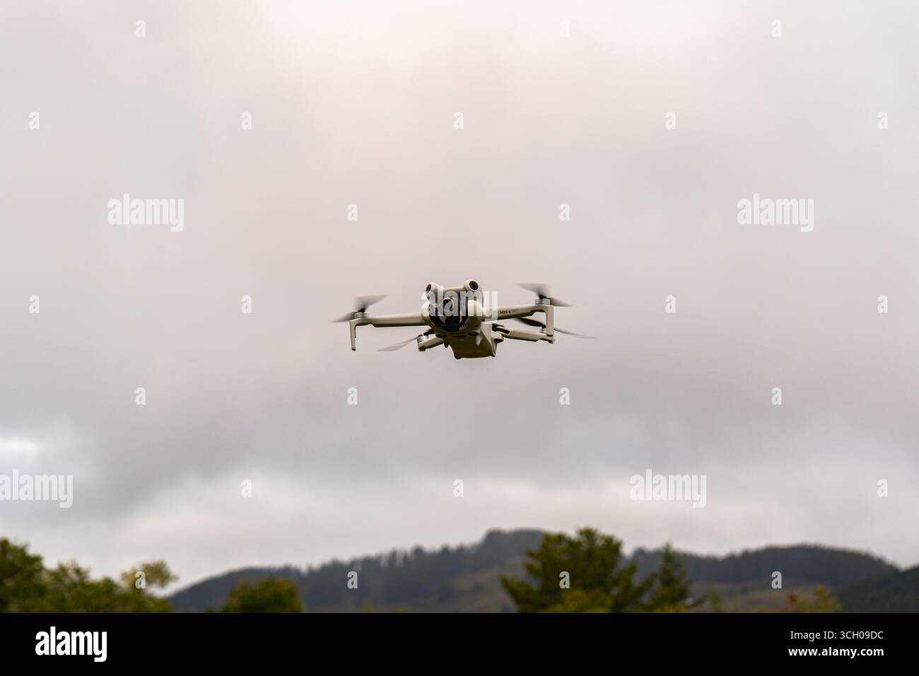 Dron volando en el cielo sobre árboles y montañas/Drone flying in the sky above trees and mountains Stock Photo