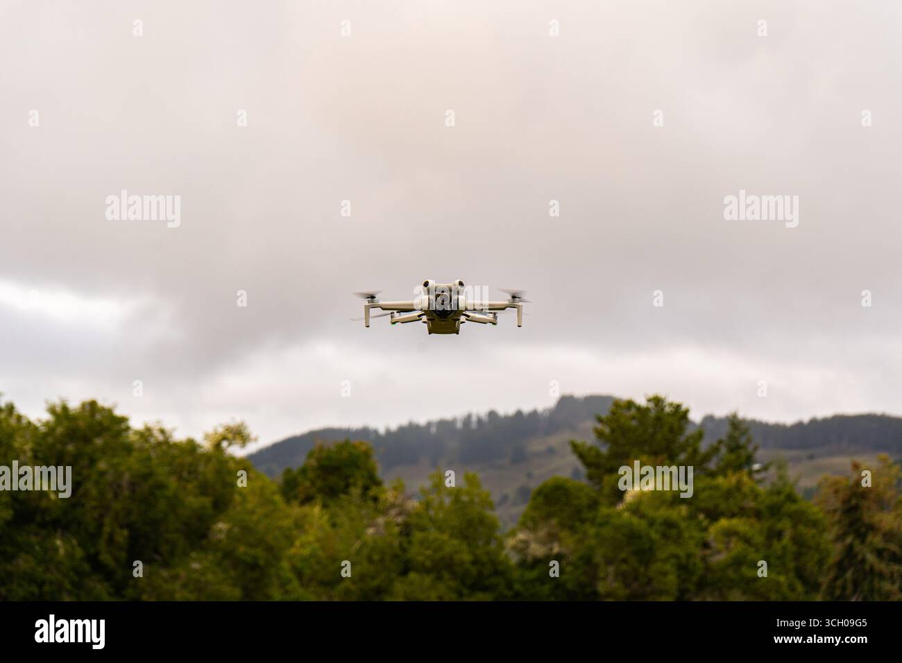 Dron volando en el cielo sobre árboles y montañas/Drone flying in the sky above trees and mountains Stock Photo