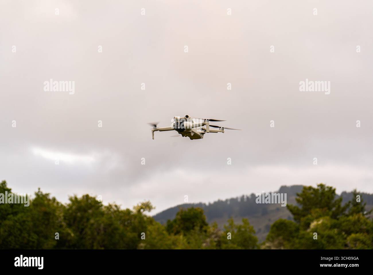 Dron volando en el cielo sobre árboles y montañas/Drone flying in the sky above trees and mountains Stock Photo