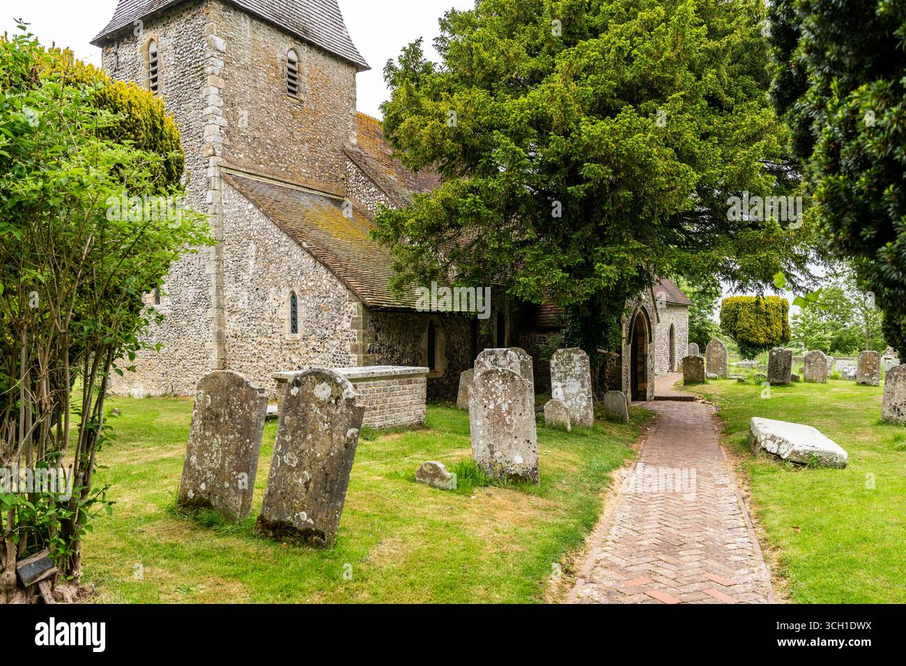 St Peter's Church and graveyard, historic Norman architecture near Monk's House where writer Virginia Woolf lived, in East Sussex, United Kingdom. Stock Photo