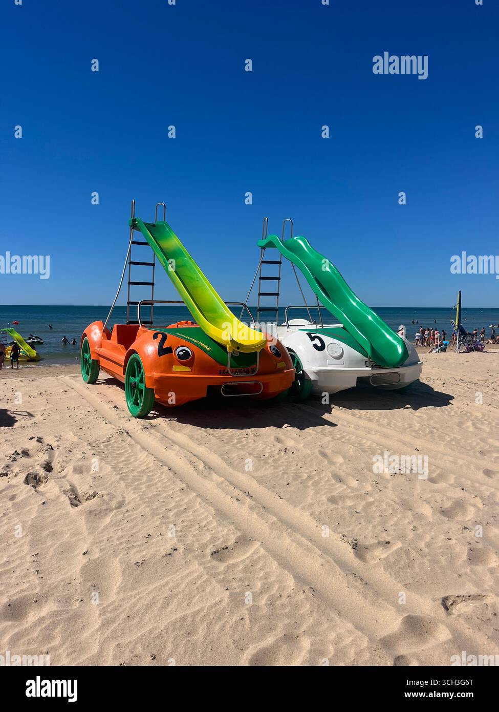 Amphibious pedal cars with slides parked on the sandy beach of Monte Gordo, Algarve, Portugal. - Smartphone Captured Stock Image