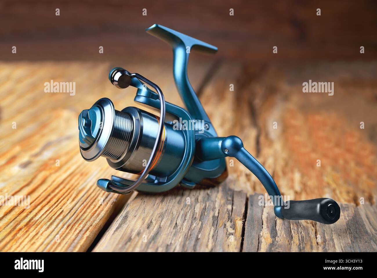 spinning reel lying on wooden rustic background close up selective focus Stock Photo
