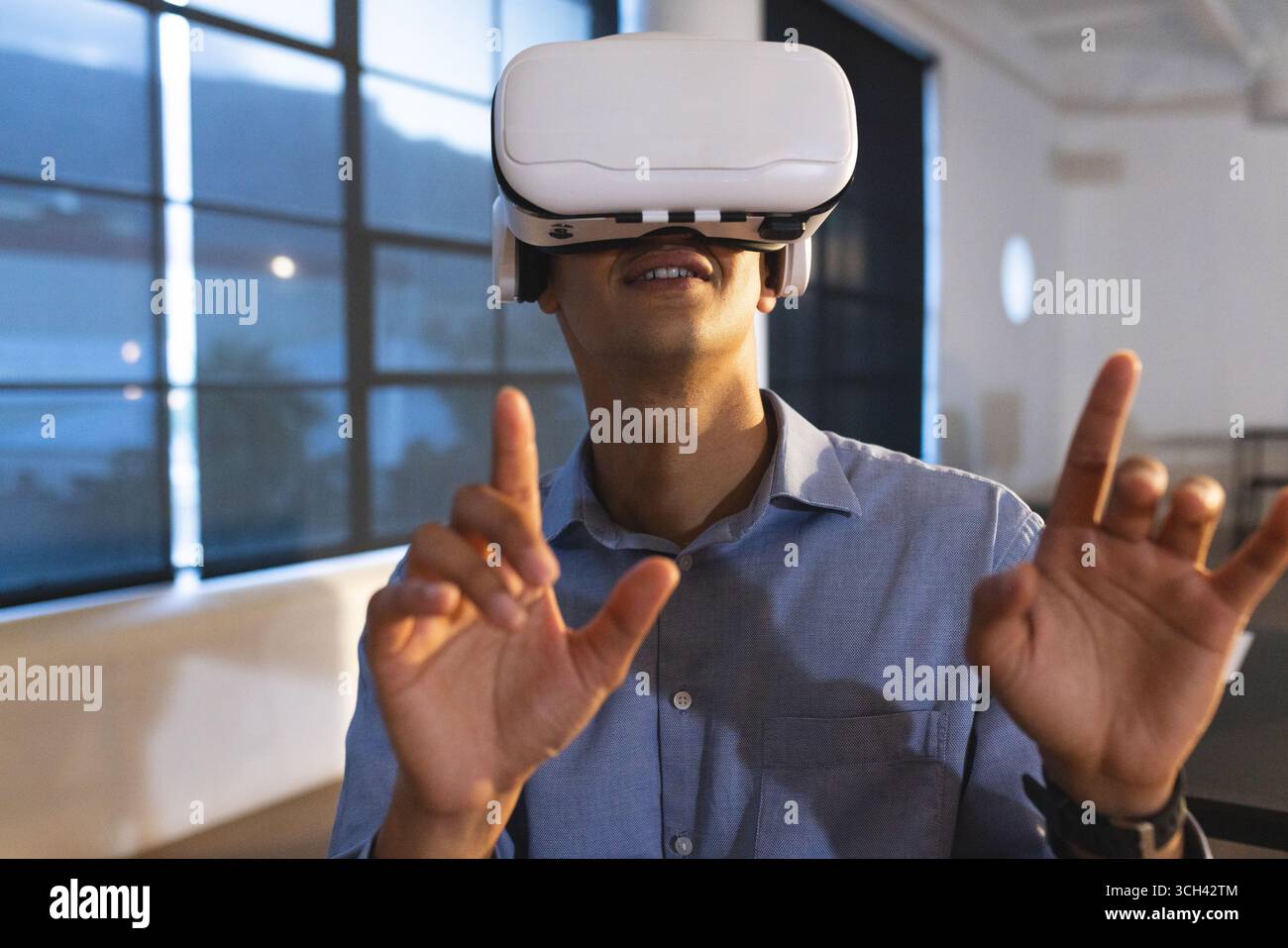 Man using VR headset in modern office, exploring virtual reality technology Stock Photo