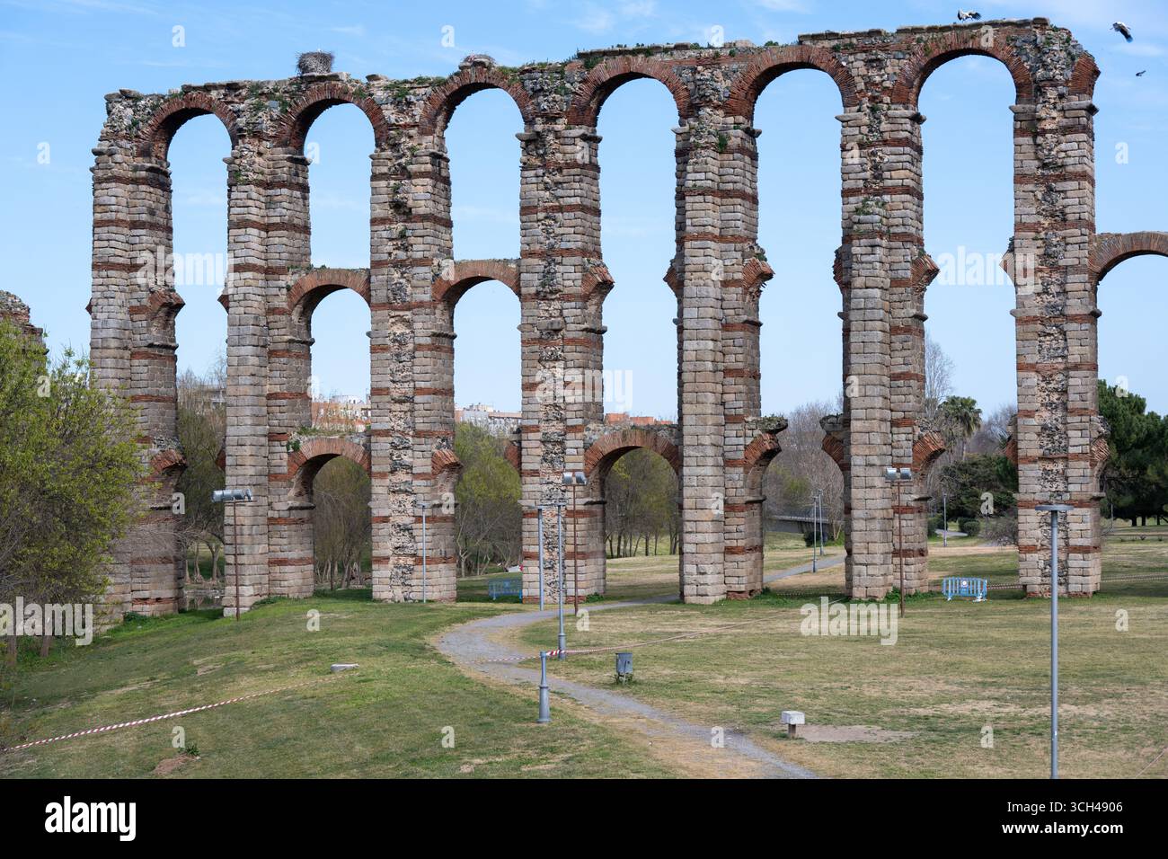 Ancient Roman aqueduct of Los Milagros with multiple arches in a grassy ...