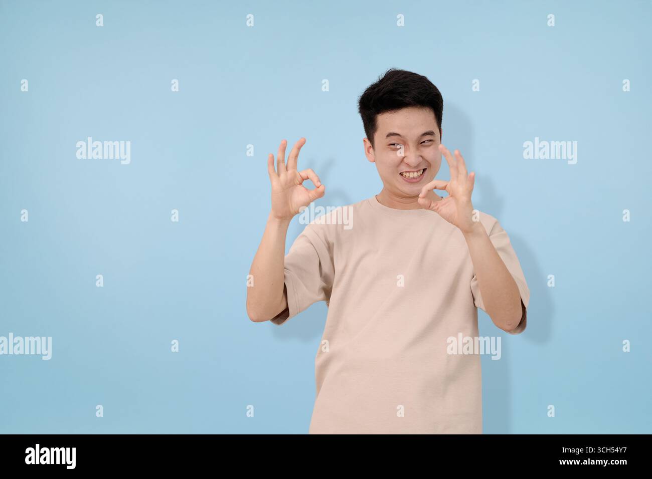 young man making ok gesture in studio background Stock Photo