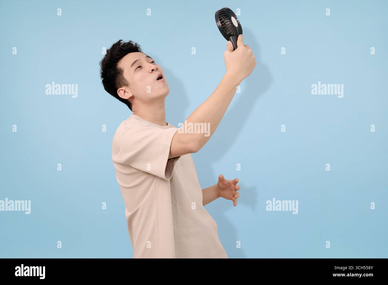People Using Handheld Fan man using handheld fan to cool down on a warm summer day Stock Photo ...