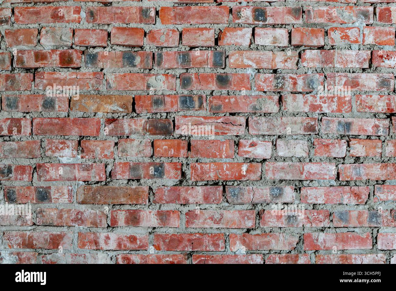 Close-up of an old red brick wall with rough mortar and weathered ...