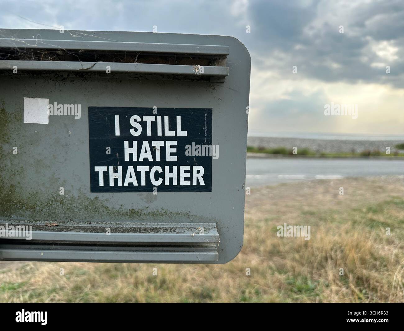 A sticker stating I still hater Thatcher on the backside of a sign at Newgale Beach, Wales Stock Photo