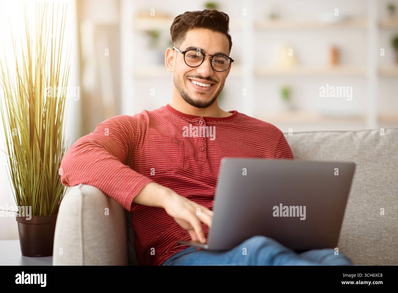 Positive arab man freelancer working from home, using notebook Stock Photo