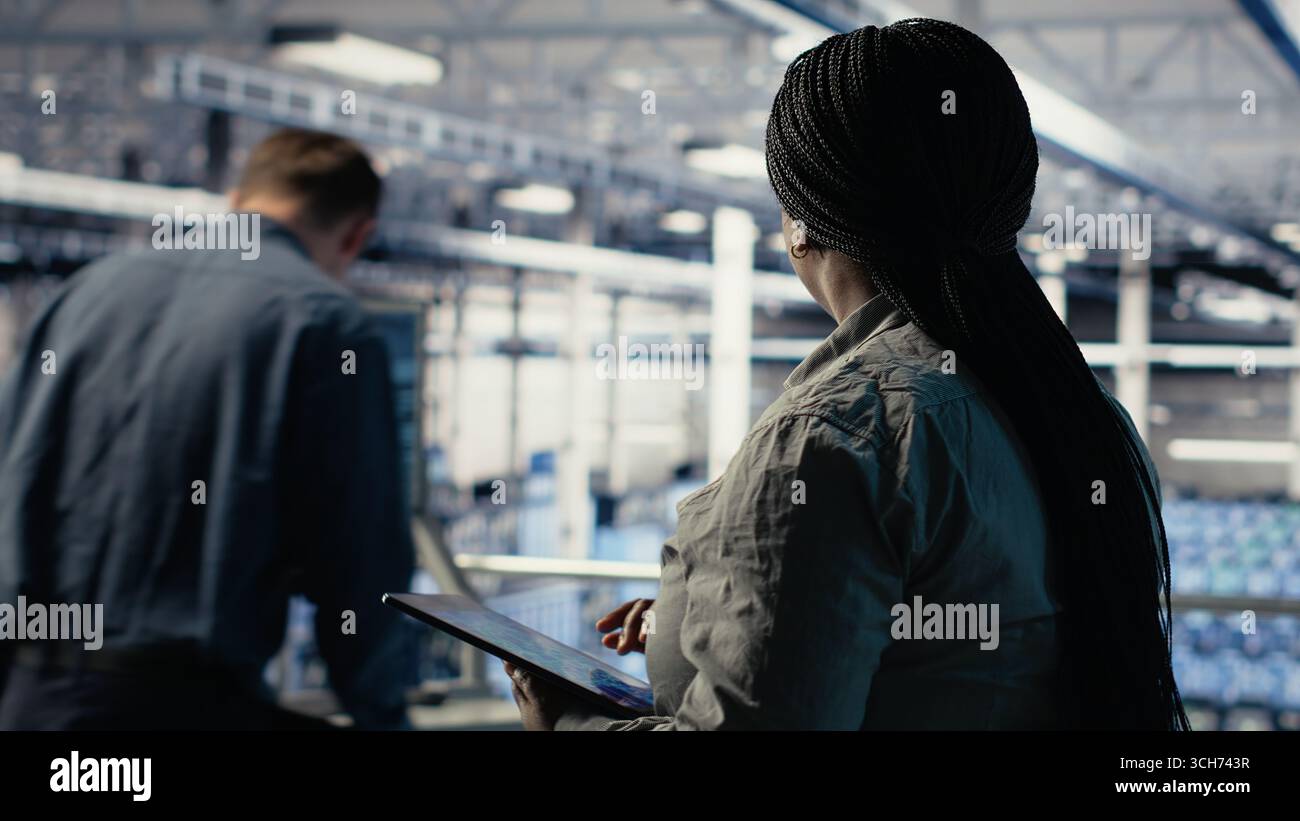 Data center employee monitoring infrastructure processes, reviewing ...