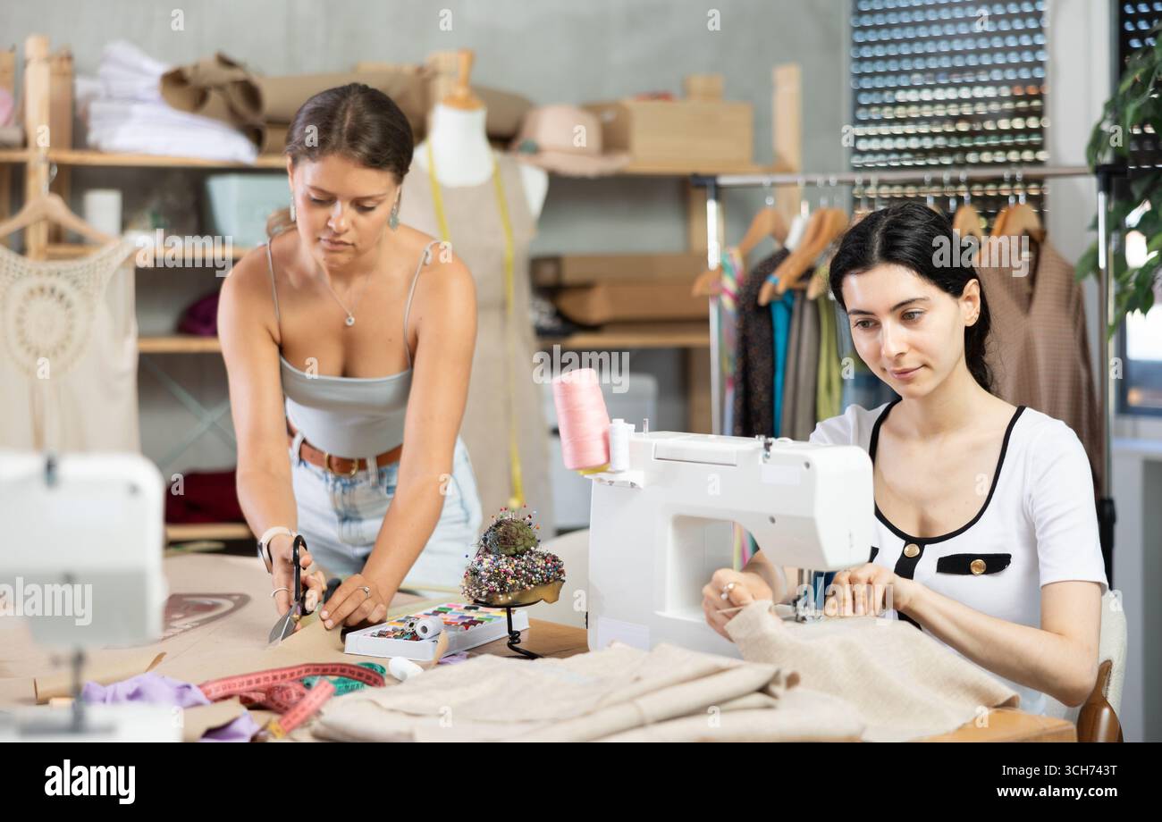 Two female tailors working on custom garment in studio Stock Photo