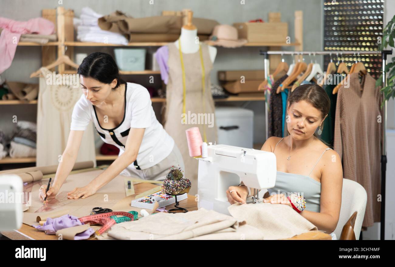 Two female tailors working on custom garment in studio Stock Photo