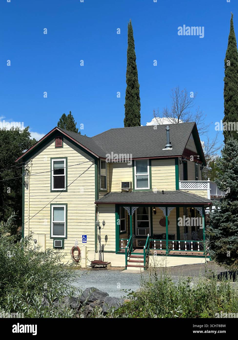 Traditional wooden house with porch and green trim - Smartphone Captured Stock Image