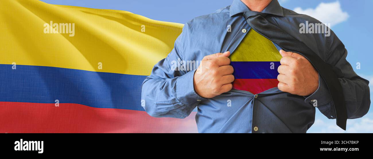 A businessman opening his shirt like super hero with Colombia flag and shows how patriotic he is by revealing his countries flag beneath printed on a Stock Photo